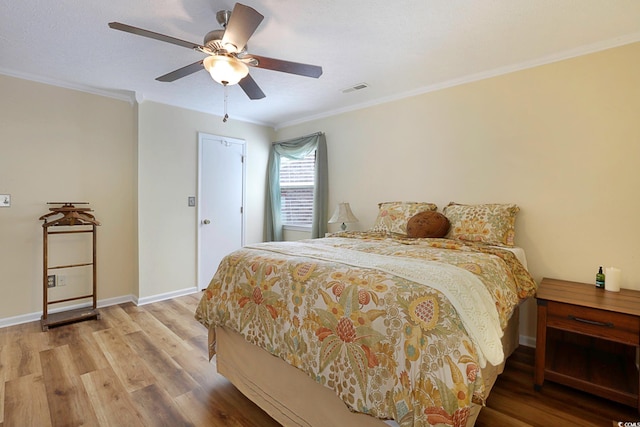 bedroom with ceiling fan, light hardwood / wood-style floors, and ornamental molding