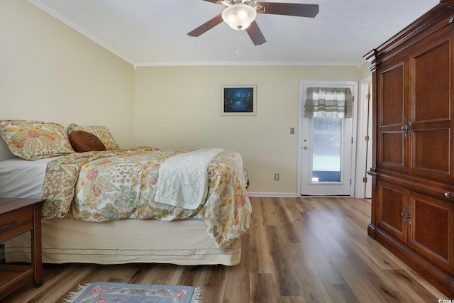 bedroom featuring hardwood / wood-style floors, crown molding, and ceiling fan