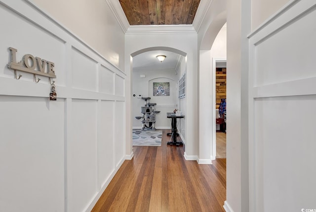 hall with wood ceiling, crown molding, and light wood-type flooring