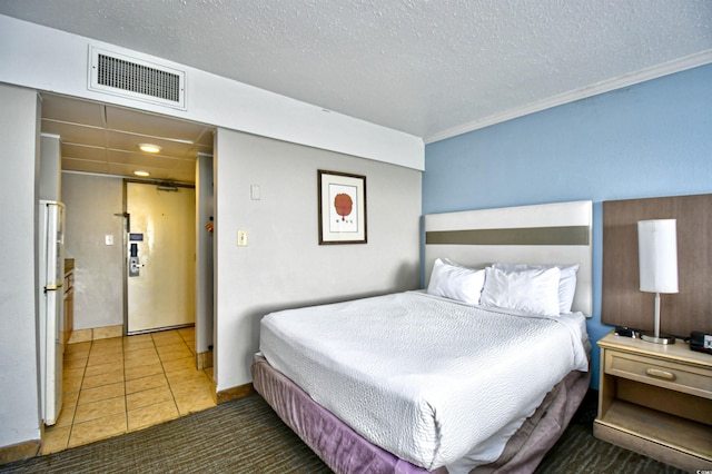 bedroom featuring a textured ceiling and dark tile patterned flooring