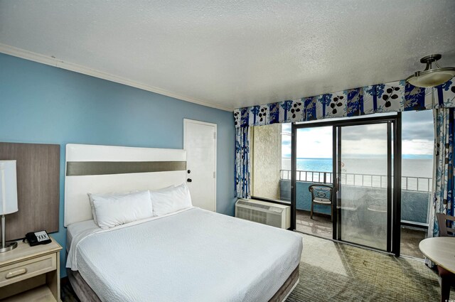 carpeted bedroom with a water view, a textured ceiling, access to outside, and crown molding