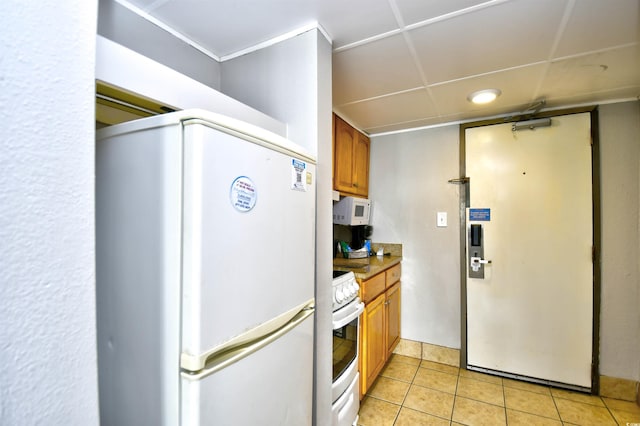 kitchen with white appliances and light tile patterned flooring