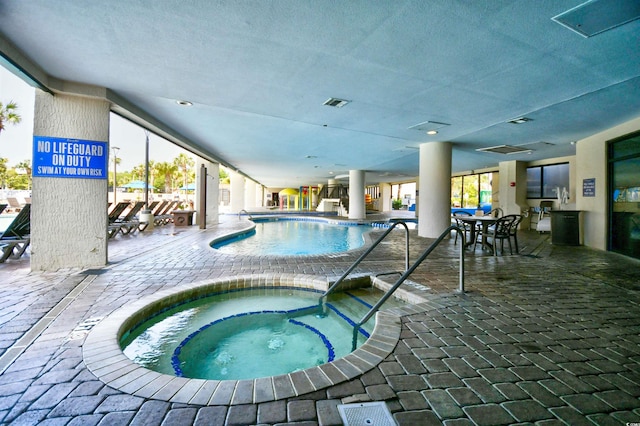 view of swimming pool featuring an indoor hot tub and a patio area