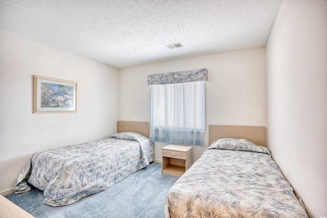 bedroom with a textured ceiling and carpet floors