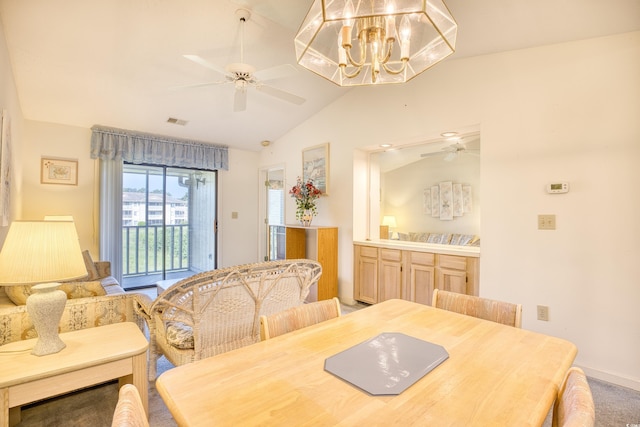 carpeted dining room with vaulted ceiling and ceiling fan with notable chandelier