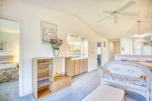 interior space featuring ceiling fan, vaulted ceiling, and light colored carpet