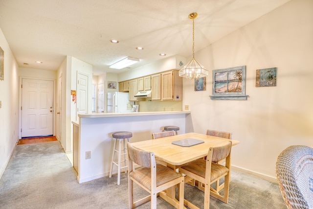 carpeted dining space featuring a chandelier