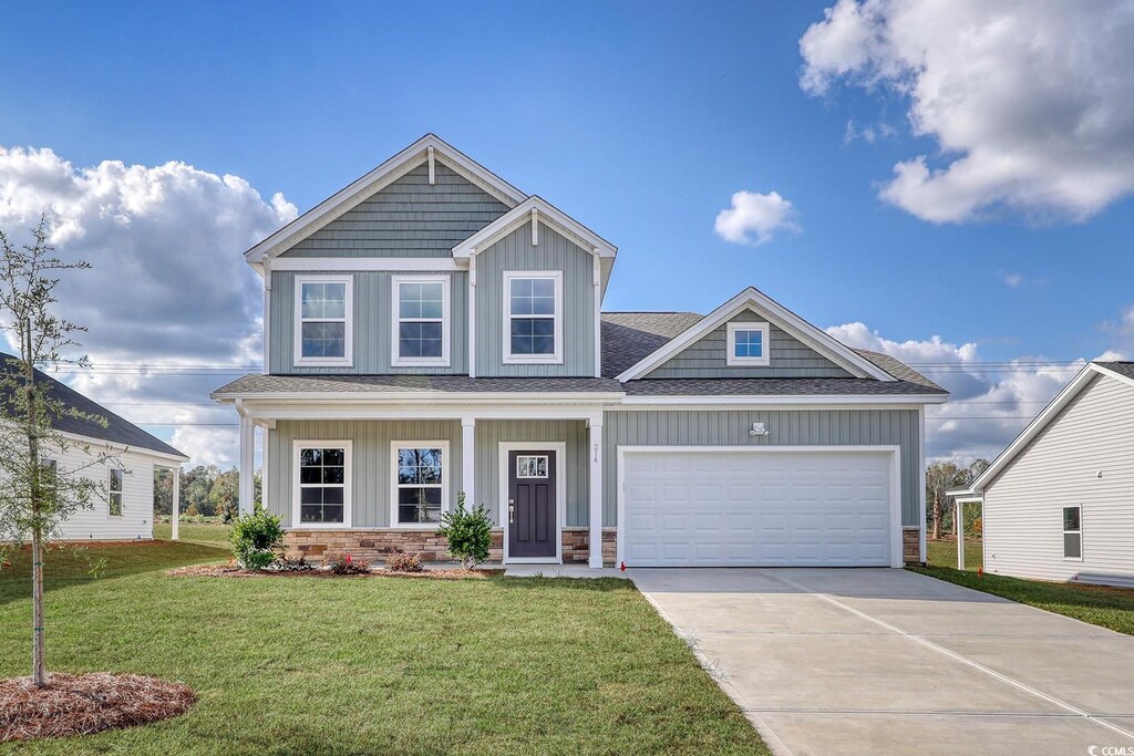 craftsman inspired home featuring a garage and a front yard