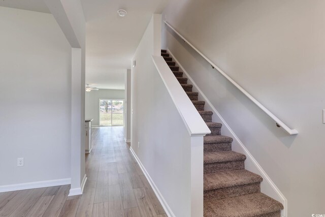 stairway with crown molding and dark hardwood / wood-style floors