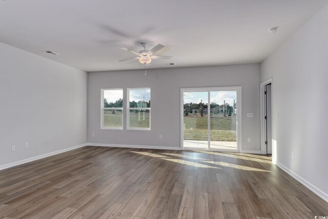 living room with ceiling fan, hardwood / wood-style flooring, crown molding, and a high end fireplace