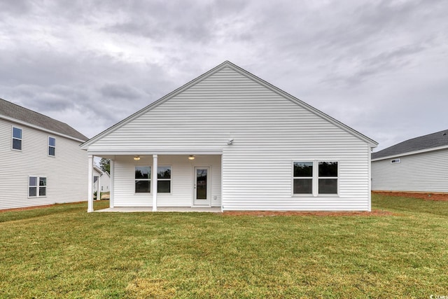 rear view of property featuring a lawn and a patio area