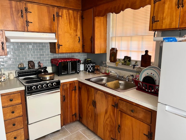 kitchen with decorative backsplash, white appliances, sink, and light tile patterned floors