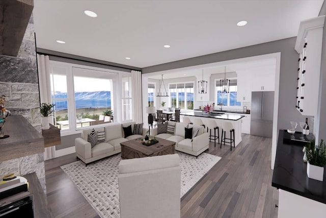 living room featuring sink, a mountain view, dark wood-type flooring, and a stone fireplace