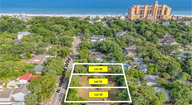 drone / aerial view with a water view, a beach view, and a residential view