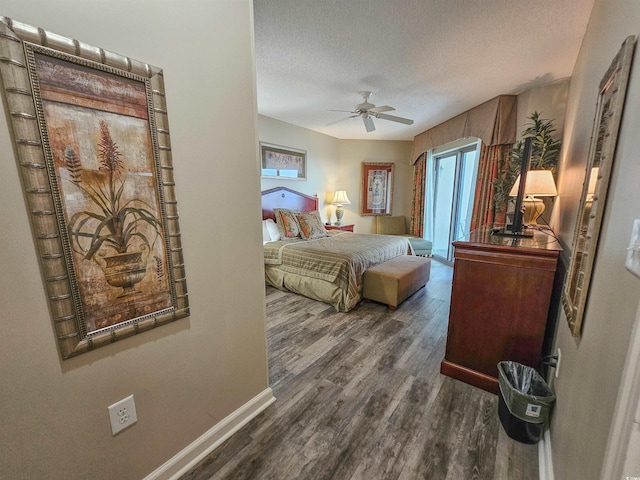 bedroom featuring ceiling fan, dark hardwood / wood-style floors, a textured ceiling, and access to outside