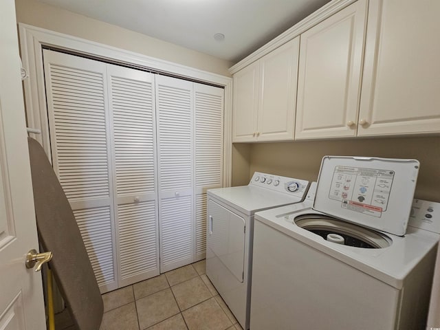 laundry room with cabinets, light tile patterned floors, and independent washer and dryer