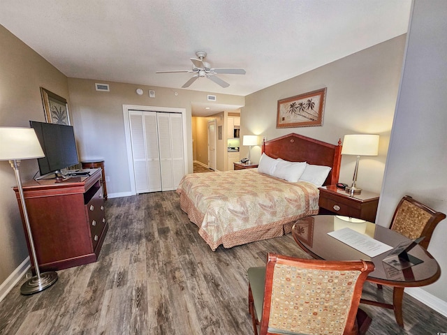 bedroom featuring ceiling fan, dark wood-type flooring, a closet, and a textured ceiling