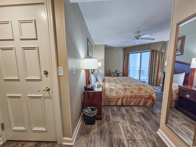 bedroom with dark hardwood / wood-style flooring, ceiling fan, and a textured ceiling