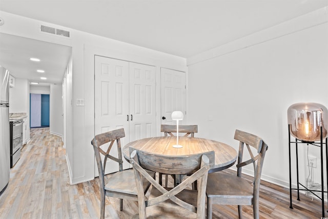 dining space with light hardwood / wood-style flooring