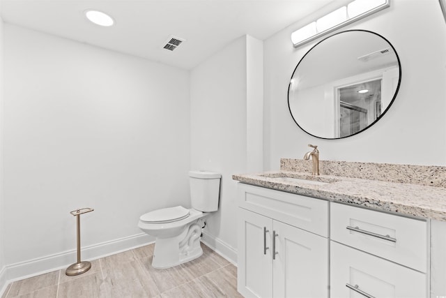 bathroom with wood-type flooring, vanity, and toilet