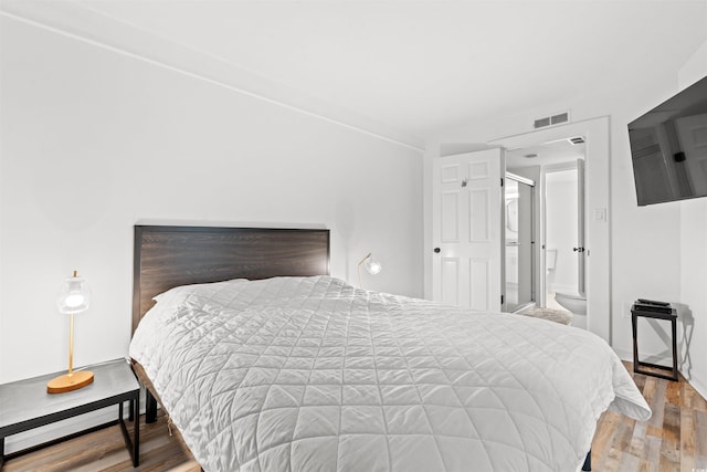 bedroom featuring wood-type flooring and ensuite bathroom