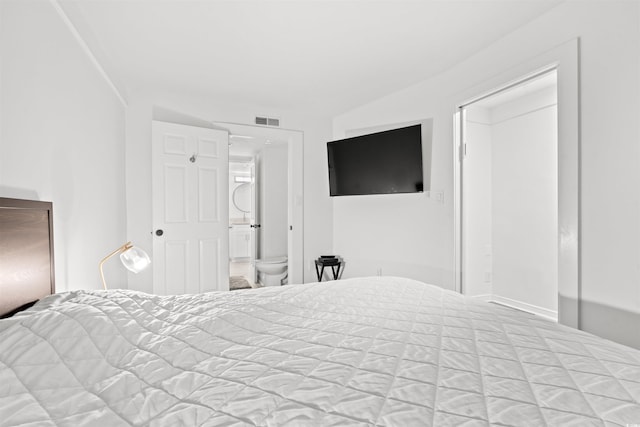 bedroom featuring lofted ceiling and connected bathroom