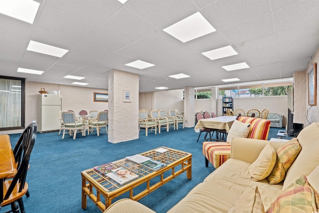 living room featuring a drop ceiling and carpet flooring