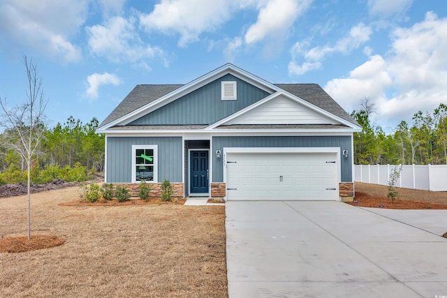 craftsman inspired home featuring an attached garage, concrete driveway, roof with shingles, and fence