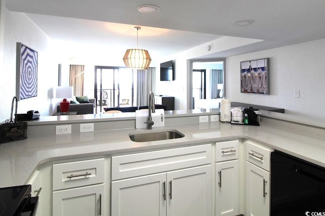 kitchen featuring sink, white cabinets, pendant lighting, and black dishwasher