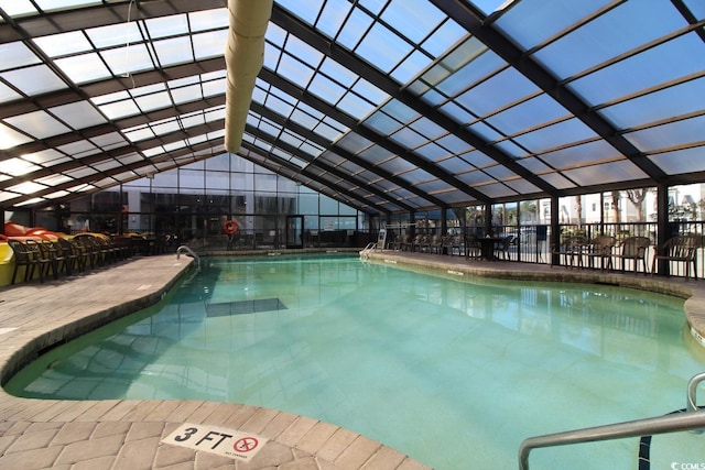 view of pool with glass enclosure and a patio