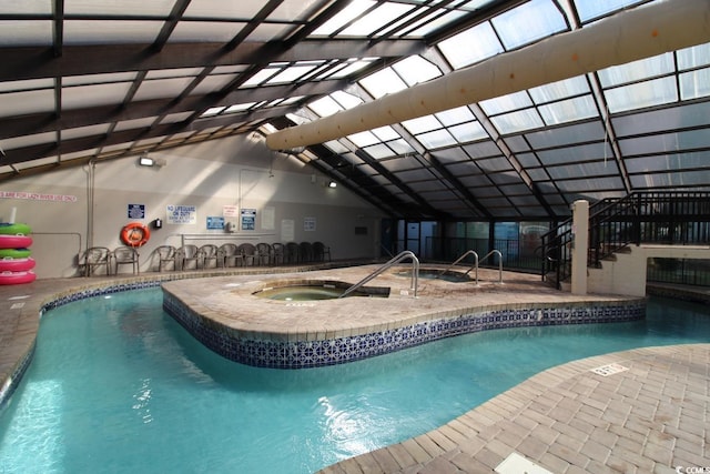 view of pool featuring glass enclosure, a patio area, and an indoor hot tub