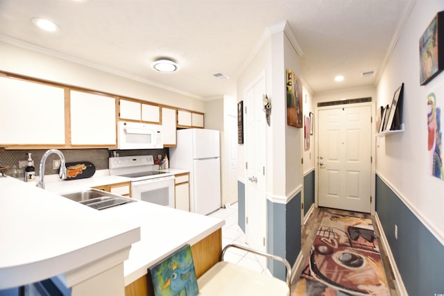 kitchen featuring white appliances, kitchen peninsula, sink, and light tile patterned flooring