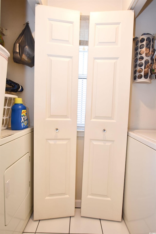 clothes washing area with independent washer and dryer and light tile patterned floors