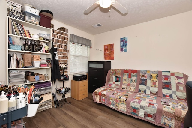 interior space with a textured ceiling, ceiling fan, and dark hardwood / wood-style floors