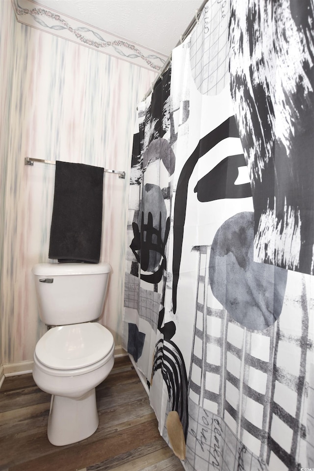 bathroom featuring toilet, curtained shower, and hardwood / wood-style floors