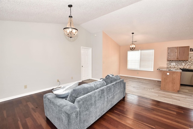 living room with baseboards, lofted ceiling, wood finished floors, an inviting chandelier, and a textured ceiling