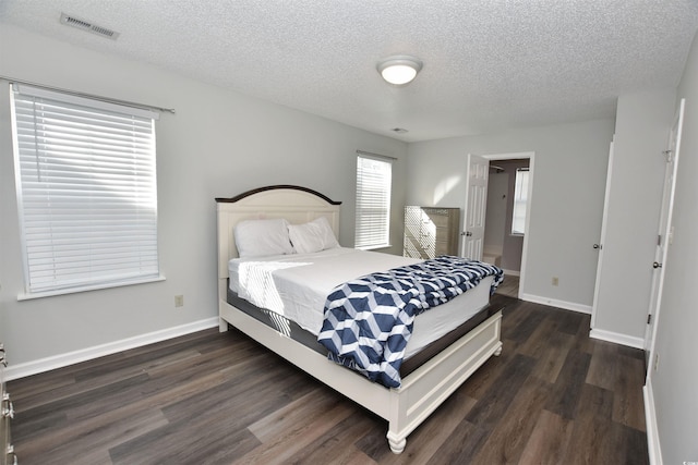 bedroom with baseboards, visible vents, and dark wood-type flooring