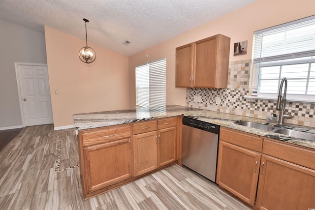 kitchen with lofted ceiling, stainless steel dishwasher, a sink, light stone countertops, and a peninsula