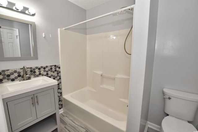 full bath with  shower combination, vanity, toilet, and a textured ceiling