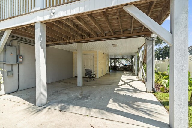 view of parking / parking lot with a carport and electric panel