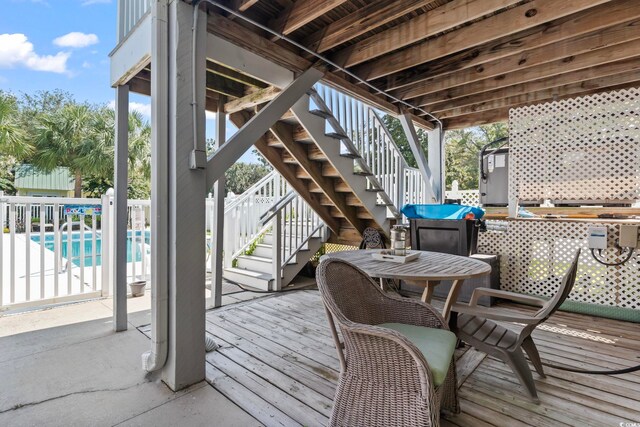 wooden terrace featuring a fenced in pool and a patio