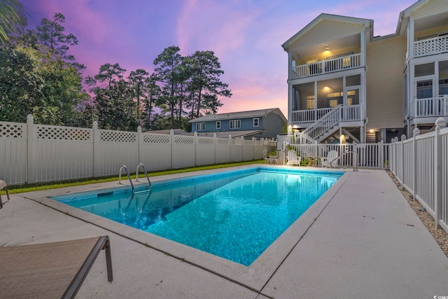 pool at dusk with a sunroom