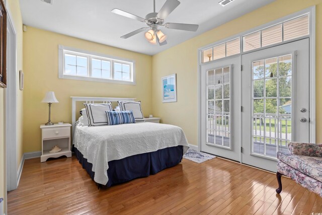 bedroom with ceiling fan, wood-type flooring, and multiple windows