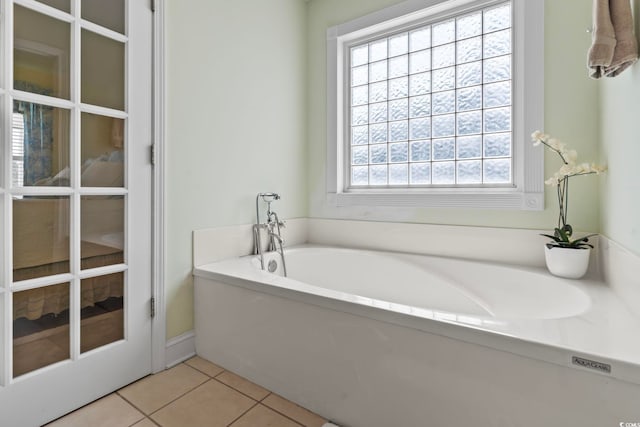 bathroom featuring tile patterned floors and a bath