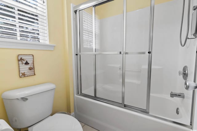 bathroom with shower / bath combination with glass door and toilet