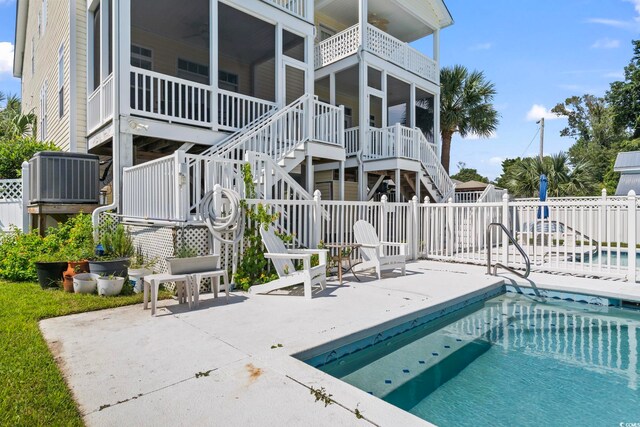 view of swimming pool featuring a sunroom and a patio