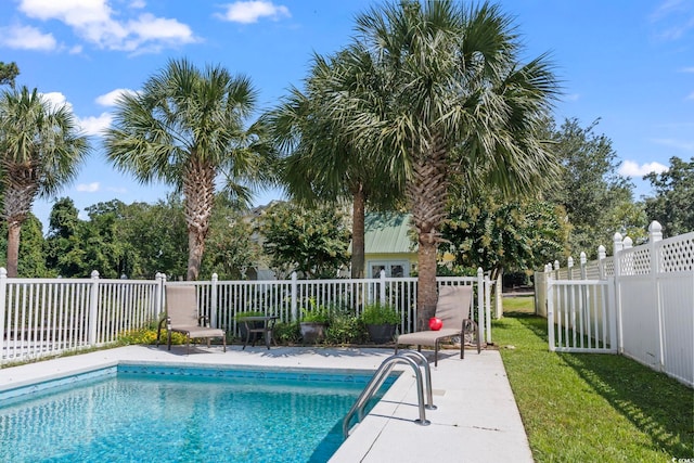 view of pool with a lawn and a patio