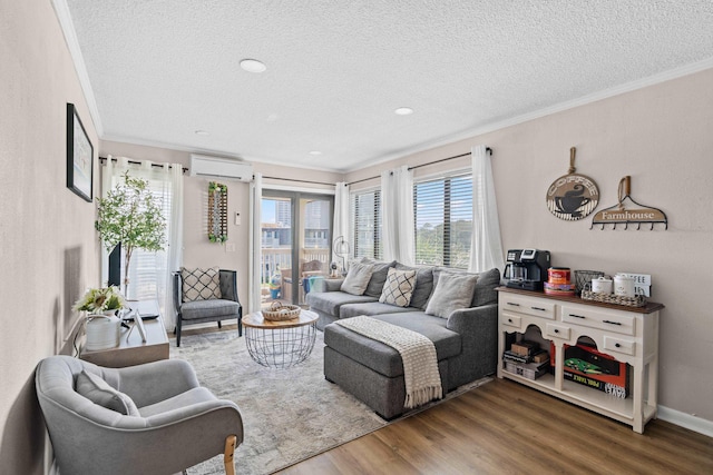 living room with a wall unit AC, crown molding, a textured ceiling, and wood finished floors