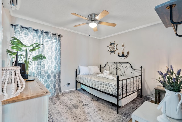 bedroom featuring baseboards, ornamental molding, and a textured ceiling