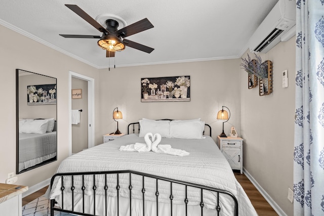 bedroom with baseboards, ceiling fan, wood finished floors, crown molding, and an AC wall unit